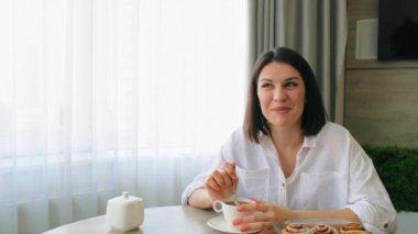 Neşeli güzel genç kız kahvaltı sırasında refakatçisiyle neşeyle iletişim kurar. Aile ortamında bir sabah. Bir fincan kahveli nazik kadın..