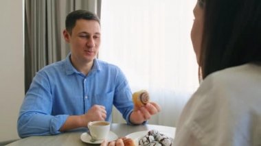 Yakışıklı genç adam, koca kızla ve karısıyla kahvaltıda diyalog kuruyor. Aile sabahı evde. Aşık mutlu evli bir çift. Karşılıklı oturun..