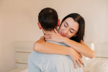 Mutlu kadın kocasına sarılır, tanıştığına memnun olur ya da sunar. Sevgili erkek arkadaşıyla genç kız arkadaşını sevmek, sarılmalar, kucaklaşmalar. Aile ilişkileri kavramı.
