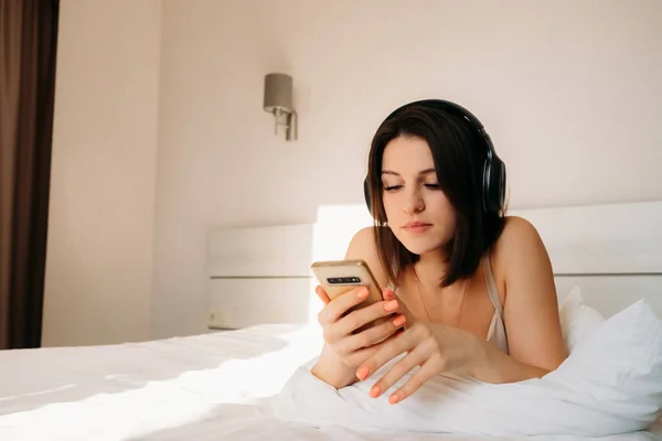 Kafkas görünümlü genç bir kız yatak odasında kulaklıkla müzik dinliyor. En sevdiğin müziği dinle ya da sabahları evde haberleri izle..