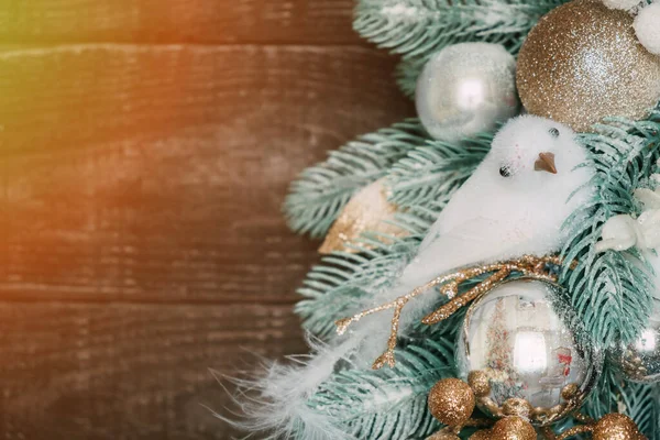 Koyu ahşap arka planda oturan beyaz bir kuşun olduğu bir Noel çelengi. Noel süslemesi.