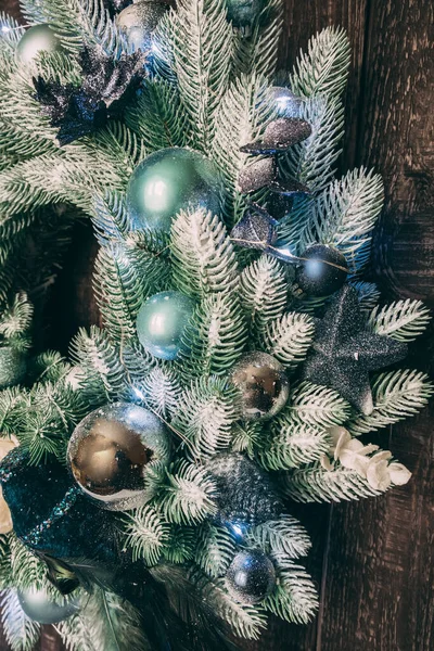 Ahşap bir kapının üzerinde yeni yıl çelengi var. Ev için Noel süslemesi.