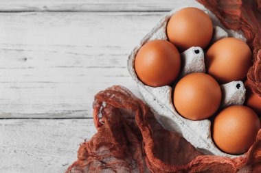 Tabakta istiflenmiş kahverengi tavuk yumurtası tepsisinin üst görüntüsü. Paketlemede yiyecek.