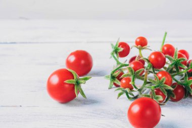 Beyaz ahşap masada kiraz domatesleri. Salata ya da garnitür malzemeleri..