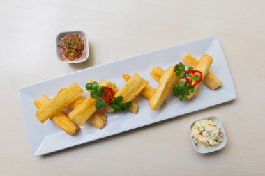 Kızarmış yuccas, baharatlı sarsa ve mayonez ile servis edilir..