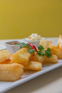 Kızarmış yuccas, baharatlı sarsa ve mayonez ile servis edilir..