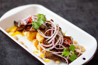 Kuru et, tipik bir Peru yemeği, yanında da yucca ve soğan sarsa sosu..