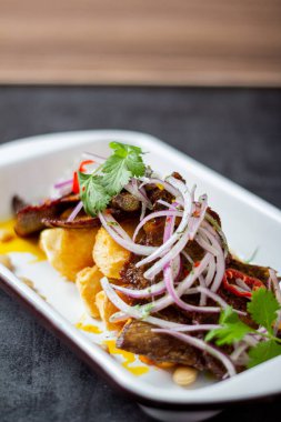 Kuru et, tipik bir Peru yemeği, yanında da yucca ve soğan sarsa sosu..