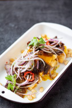 Kuru et, tipik bir Peru yemeği, yanında da yucca ve soğan sarsa sosu..