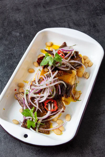 Kuru et, tipik bir Peru yemeği, yanında da yucca ve soğan sarsa sosu..