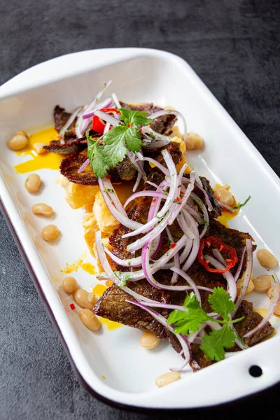 Kuru et, tipik bir Peru yemeği, yanında da yucca ve soğan sarsa sosu..