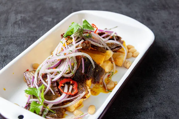 Kuru et, tipik bir Peru yemeği, yanında da yucca ve soğan sarsa sosu..