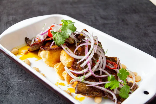 Kuru et, tipik bir Peru yemeği, yanında da yucca ve soğan sarsa sosu..