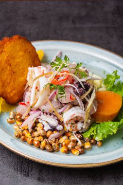 Geleneksel Peru tahliyesine balıklar, mısır gözlemesi, tatlı patates, kançita ve bol baharatlı meyve suyu eşlik ediyor..