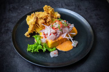 Kızarmış balıkların eşlik ettiği Causa acevichada..