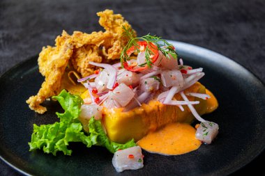 Kızarmış balıkların eşlik ettiği Causa acevichada..