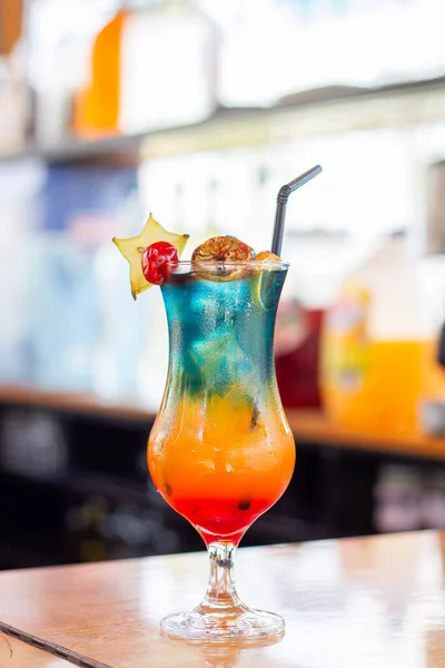 Limon dilimi ve biberiye filizi serpiştirilmiş bar arka planıyla süslenmiş buzlu, soğuk modern gurme cin ve tonik karışımı.