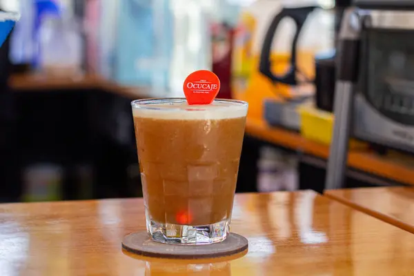 Limon dilimi ve biberiye filizi serpiştirilmiş bar arka planıyla süslenmiş buzlu, soğuk modern gurme cin ve tonik karışımı.