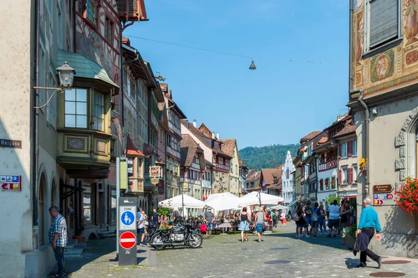 İsviçre 'nin turistik kenti Stein am Rhein' de yazın güneşli bir tatil gününde tarihi cadde, turistler, dükkanlar ve İsviçre bayrakları görülüyor. 