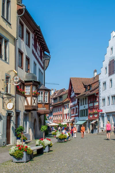 İsviçre 'nin turistik kenti Stein am Rhein' de yazın güneşli bir tatil gününde tarihi cadde, turistler, dükkanlar ve İsviçre bayrakları görülüyor. 