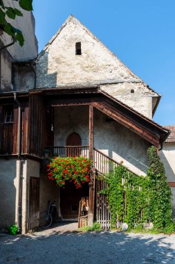 Aziz George Manastırı 'nın (Kloster Sankt Georgen) ahşap basamakları. Eski manastırın süs balkonu, bitkileri ve yıpranmış ön cephesi.