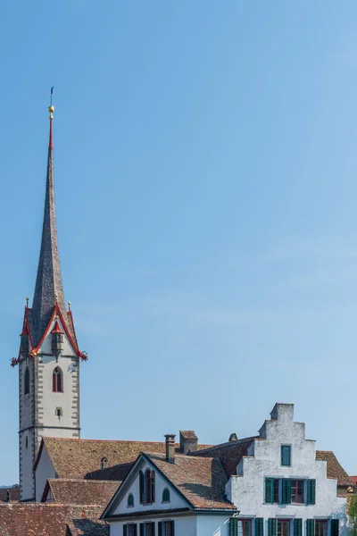 Kilisenin yüksek çan kulesi St. George Manastırı (Kloster Sankt Georgen) rüzgar gülü, kırmızı çatı, heykelcikler ve Doğu Avrupa 'daki İsviçre kasabasında altın küreler ile