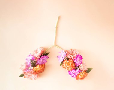 Kasımpatı çiçekleri mor ve turuncu renkte ahşap bir çubuğa dizilir. Minimum aşk düzlüğü