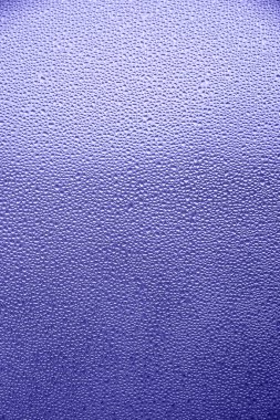 2022 yılının rengine göre ayarlanmış cam camlarına soyut su damlaları. Çok menekşe arkaplanı. 