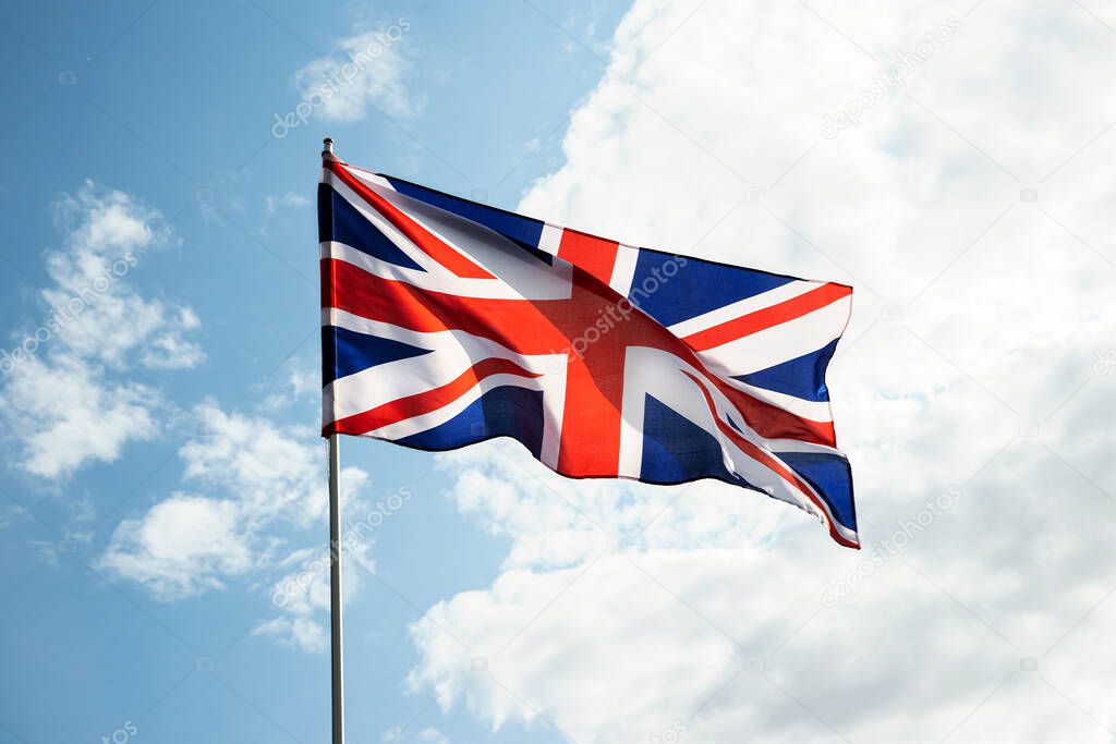 Great Britain England flag waving in the wind over blue sky