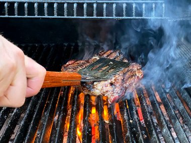 Kızarmış et barbekü bifteği alevli ızgarada, dumanlı..