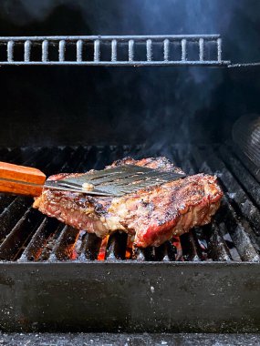 Kızarmış et barbekü bifteği alevli ızgarada, dumanlı..