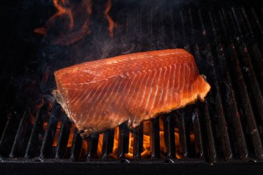 Somon balığı fileto alevli ızgarada pişiyor dumanla..