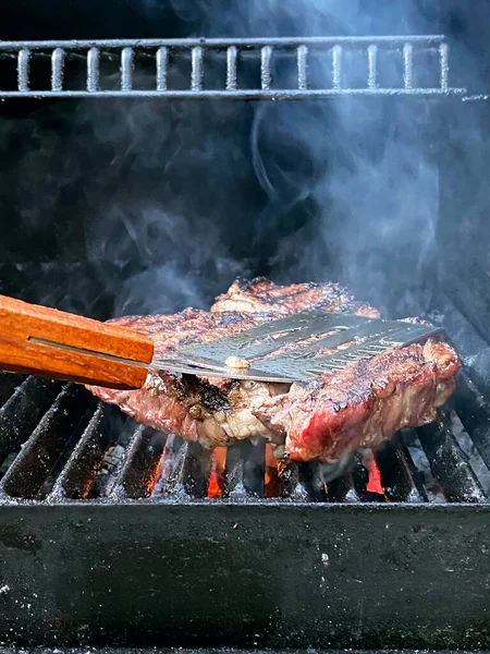 Kızarmış et barbekü bifteği alevli ızgarada, dumanlı..