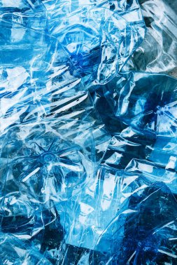 Boş buruşmuş mavi plastik şişelerin üst görünümü arka planda veya mavi arka planda veya geri dönüşümlü çöpsüz plastik kavramı yeniden kullanın.