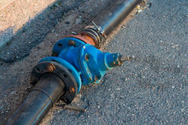 Sokakta siyah bir borunun kapakçığı kapalıymış.