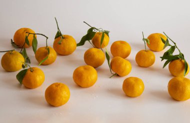Beyaz arka planda bir sürü mandalina var.