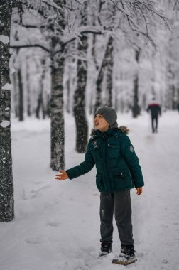 Bir çocuk kar parkında yürüyor.