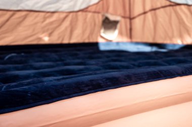 Doldurulan çadırın zeminindeki şişme şişme yatağın seçici odağı. 