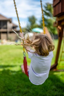 Rüzgarda savrulan uzun sarı saçlı, beyaz bir kız.