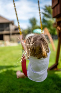 Rüzgarda savrulan uzun sarı saçlı, beyaz bir kız.