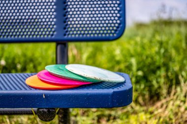 Golf sahasındaki bir bankta duran disk yığını.