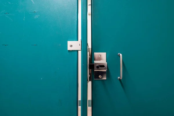 Generic metal public bathroom stall latch closed with the door gap shown. — Stock Photo, Image