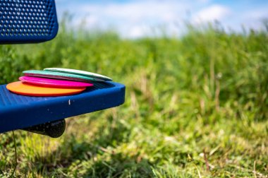 Golf sahasındaki bir bankta duran disk yığını.