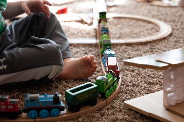 Tiffin, Iowa, ABD - 3.2021: Model Thomas the Train ile oynayan küçük çocuk. Thomas popüler bir demiryolu temalı çocuk oyuncağı.. 