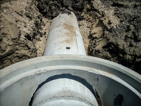 Boru bağlantılarından geçen beton rögar kapağı. — Stok fotoğraf