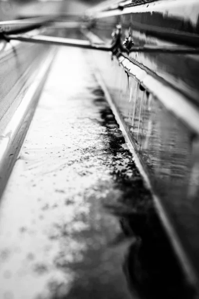 Foco seletivo em uma seção de calhas residenciais com cabide transportando água durante uma tempestade. Salpicos de chuva e gotas visíveis. — Fotografia de Stock