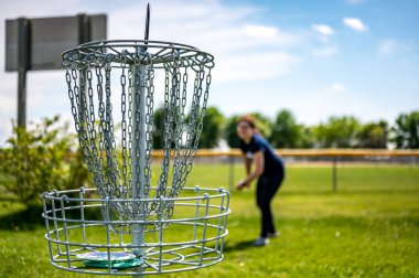 Odaklanamayan bir oyuncu tarafından fırlatılan disk havadayken bir golf deliğine odaklan