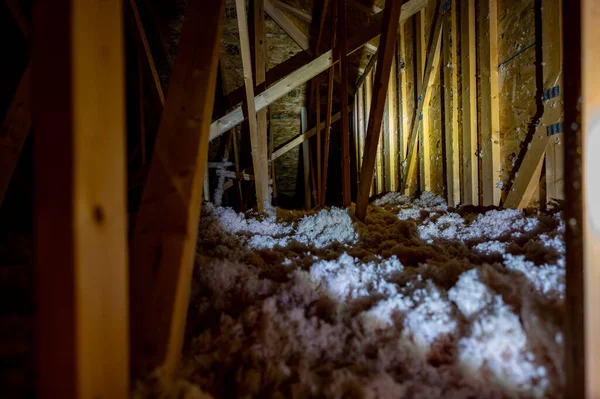Dark attic with loose blown insulation seen throughout. — Stock Photo, Image