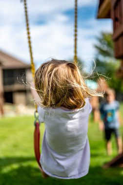 Rüzgarda savrulan uzun sarı saçlı, beyaz bir kız.