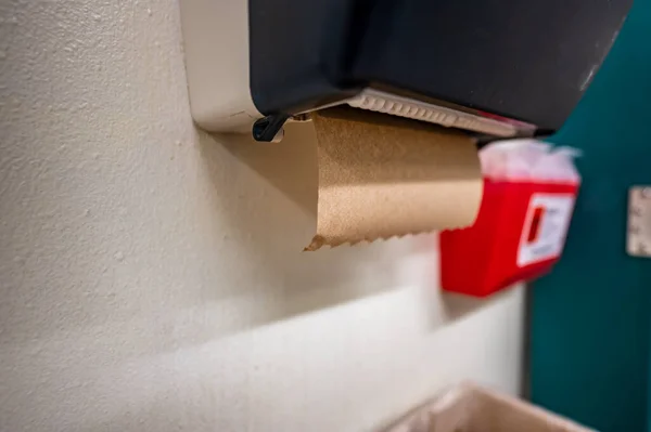 Messa a fuoco selettiva su un distributore di asciugamani di carta in un bagno utilizzato per asciugarsi le mani dopo il lavaggio. — Foto Stock